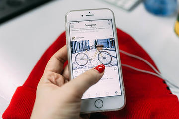 mano di donna e schermo di uno smartphone che mostra Instagram (foto: Marina Stroganova/Flickr)