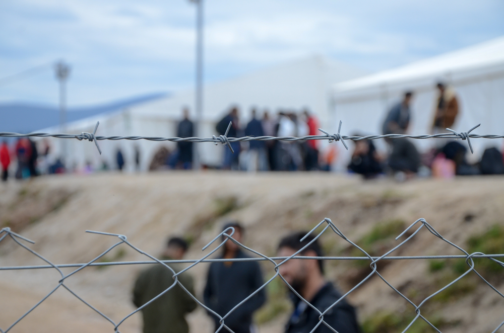 Migranti dietro il filo spinato di un campo © Ajdin Kamber/Shutterstock